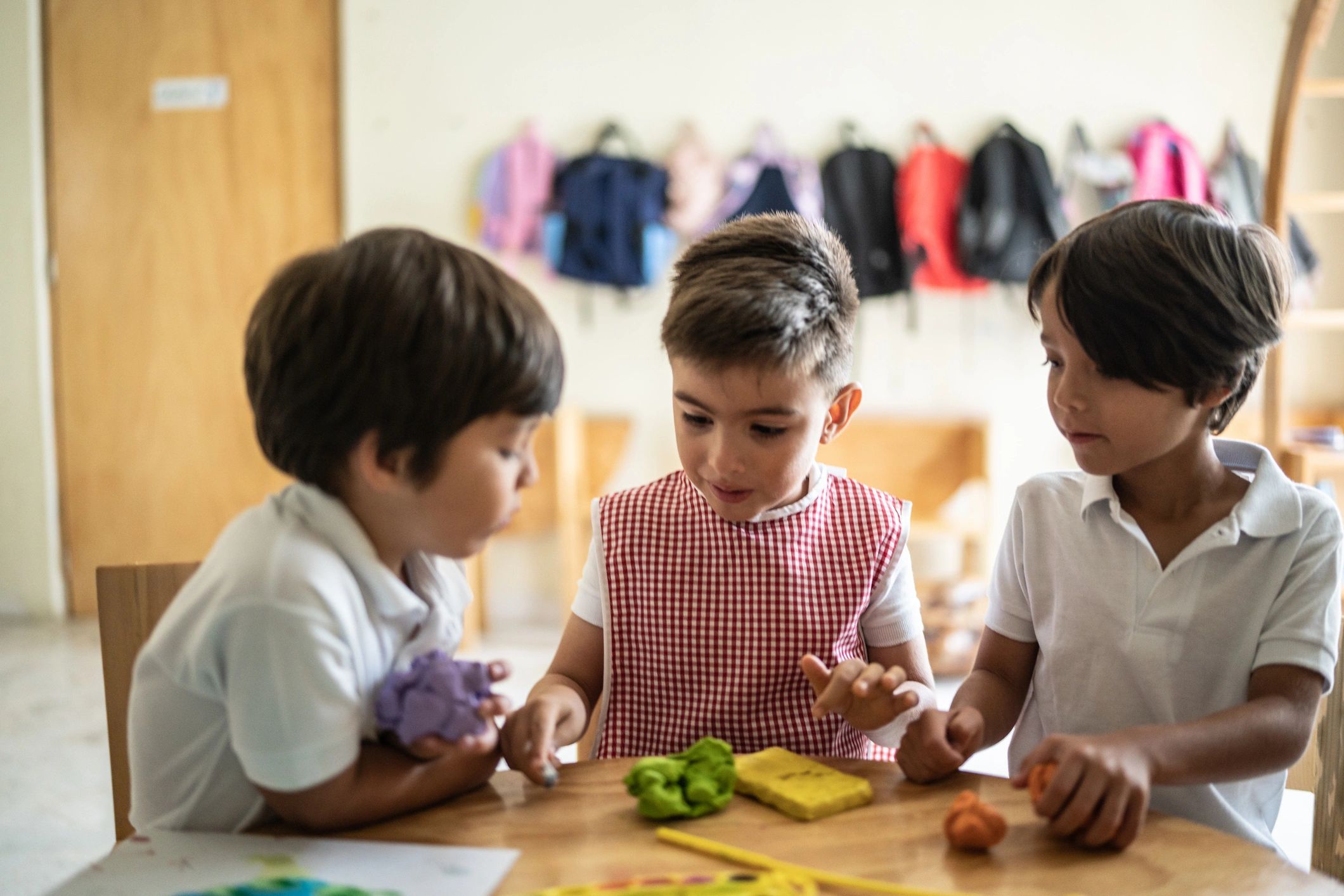 Children working with modeling clay at a classroom table