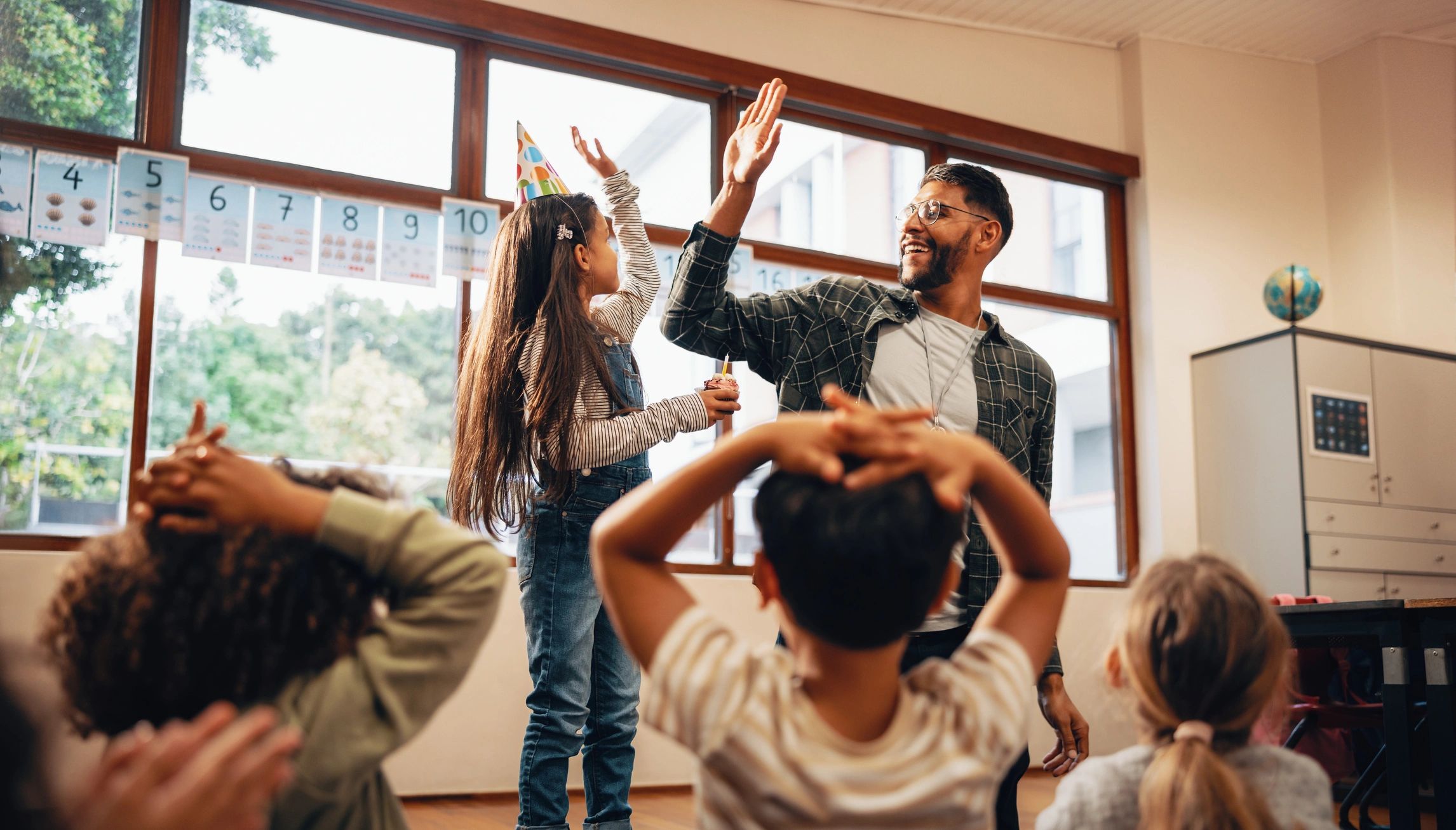 Teacher giving a student a high five in class