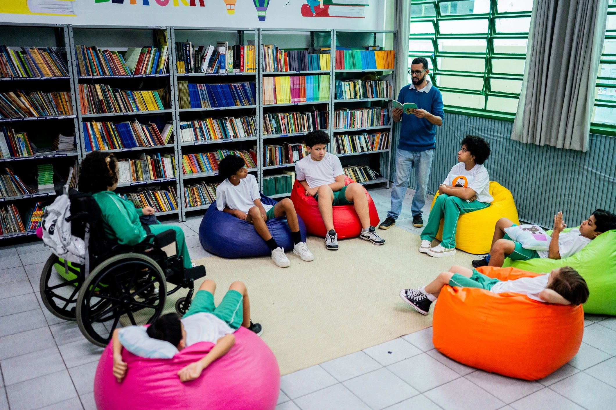 Teacher reading aloud to children in a bright, welcoming learning space