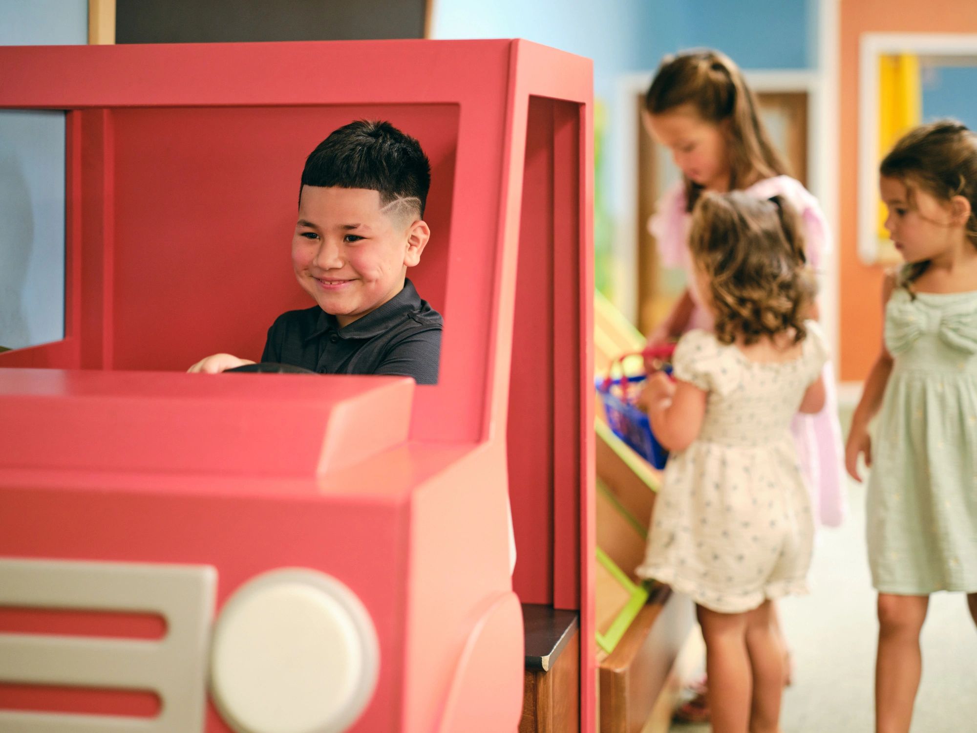Children playing together indoors in a bright activity space