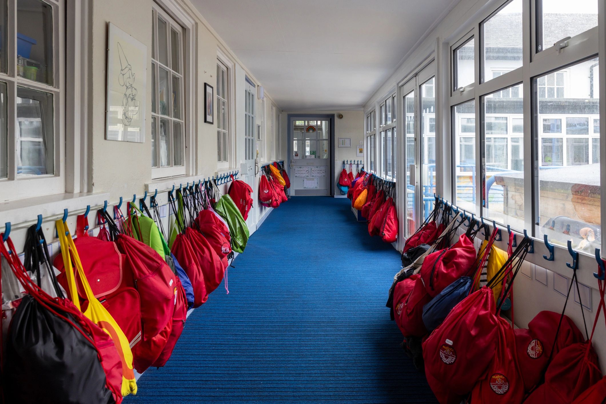 Bright school corridor with cubbies and bags, representing an organized learning environment