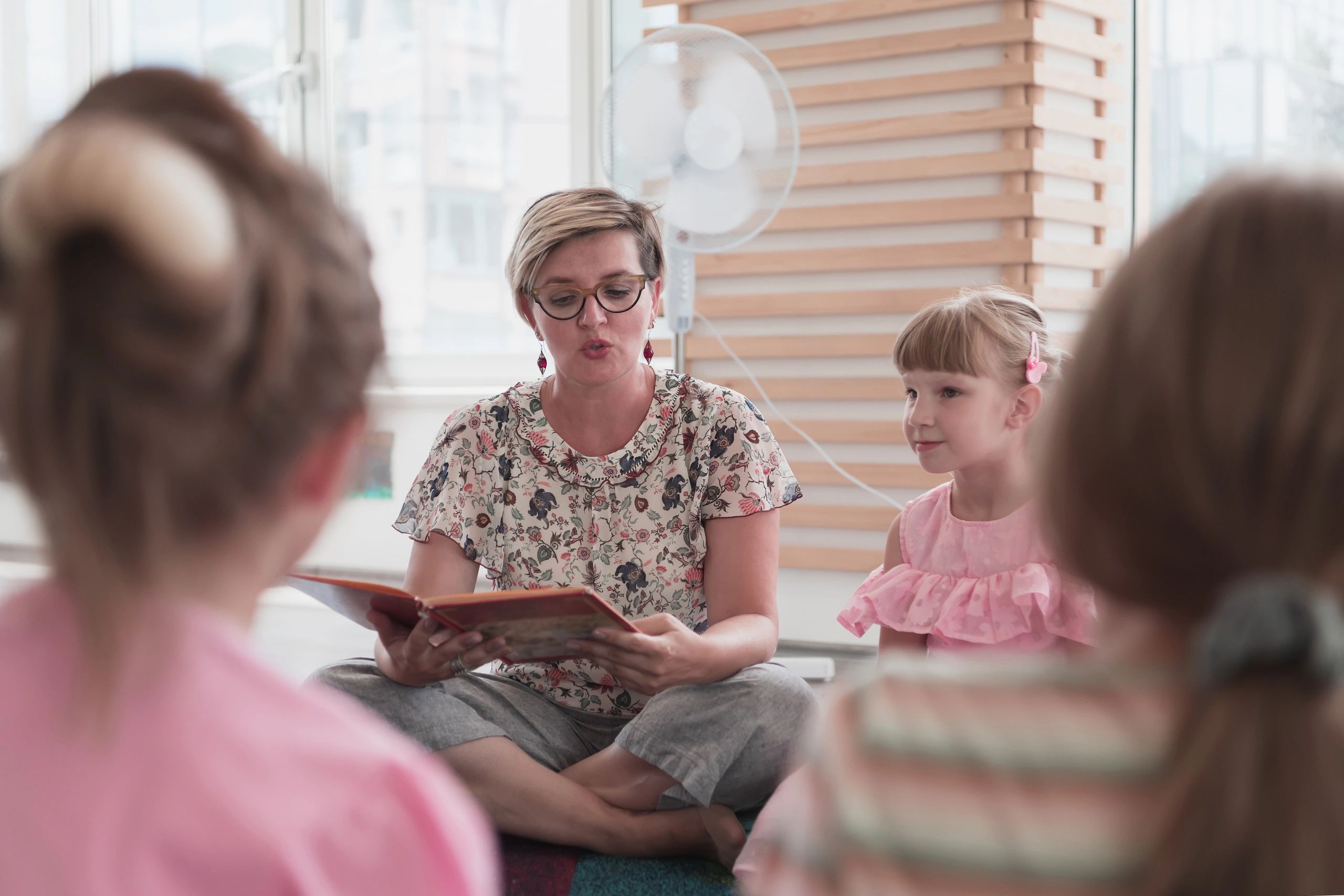 Teacher reading a book to children during story time