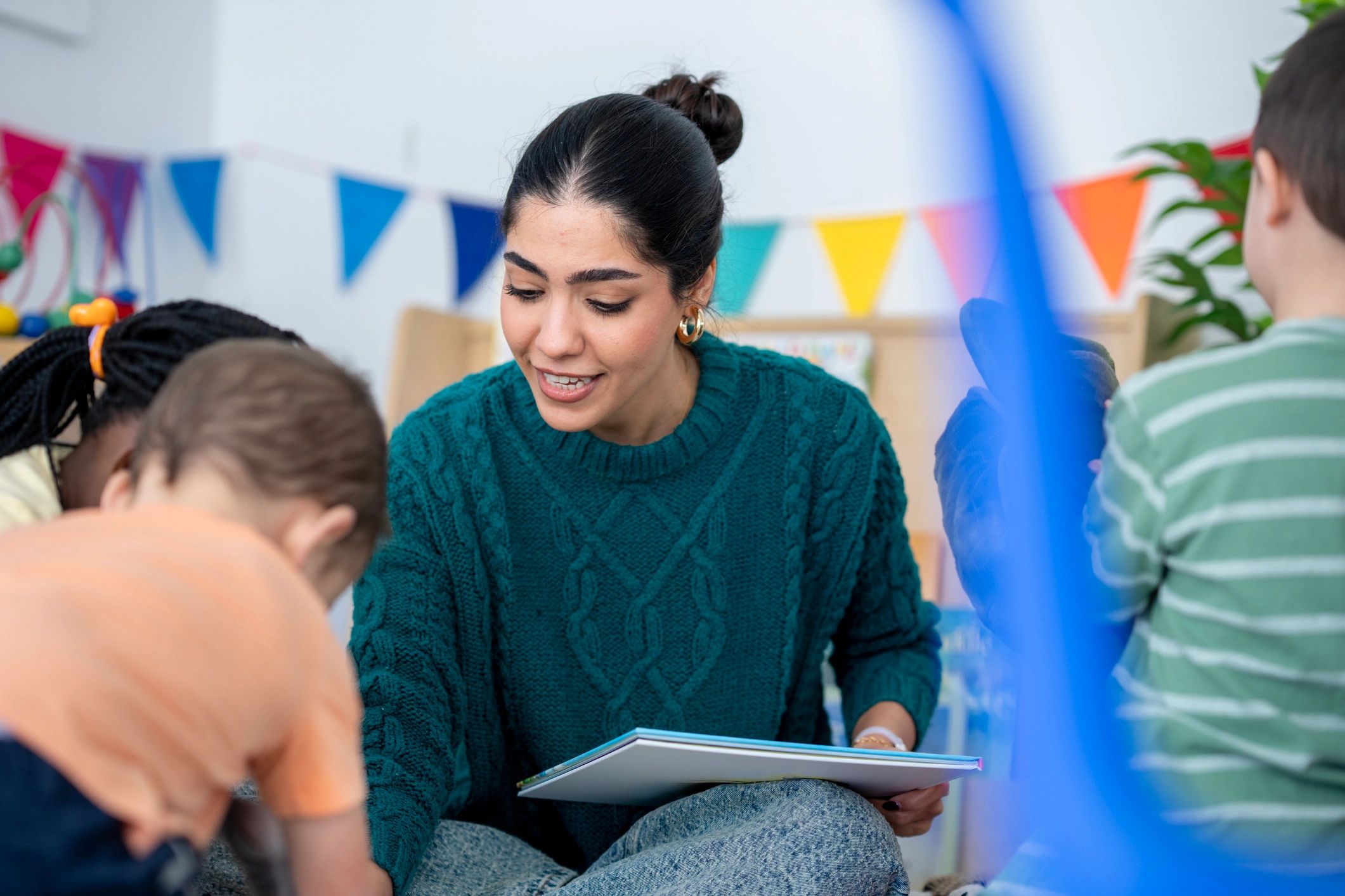 Teacher reading with children in a bright classroom
