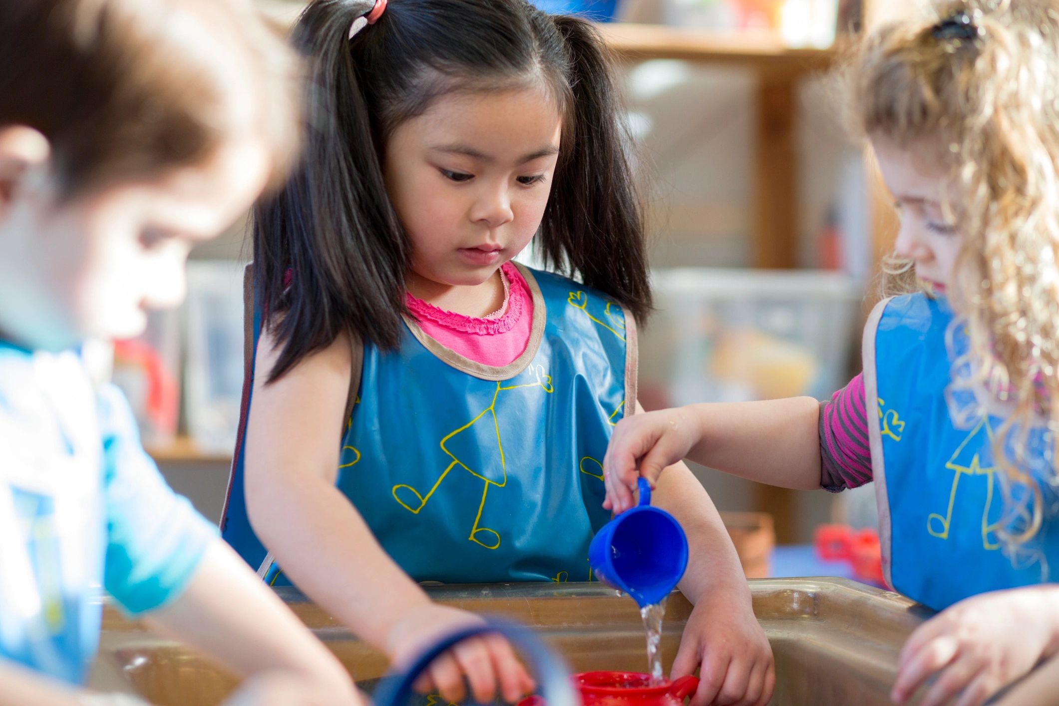 Children playing at a water table in nursery